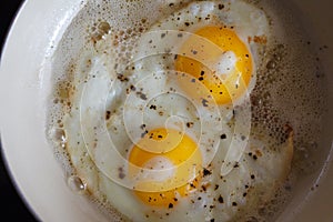 Fried eggs from 2 eggs in a frying pan. Hot Sunny dish