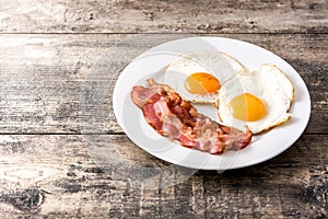 Fried eggs and bacon for breakfast on wood