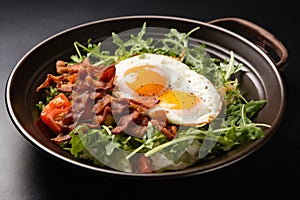 fried eggs with bacon and herbs and chopped vegetables, delicious breakfast, still life on a dark background