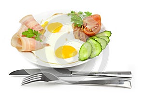 Fried eggs with bacon and vegetables