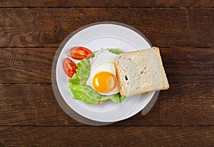 Fried eggs breakfast toast salad on wooden