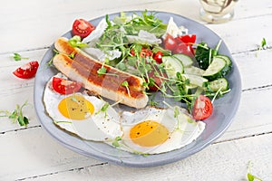 Fried eggs and chicken sausage and fresh salad