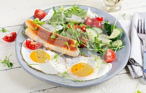 Fried eggs and chicken sausage and fresh salad