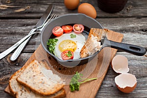 Fried eggs and fresh bread with cherry tomatoes, herbs and spices for breakfast