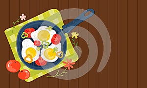 Fried eggs in a frying pan with vegetables, tomatoes, peppers. Healthy brunch with fresh homemade meal on a wooden table.