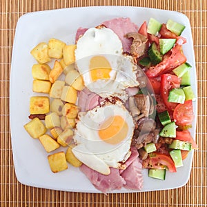 Fried eggs and ham with small roast potatoes.