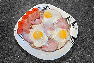 Fried eggs with ham and tomatoes