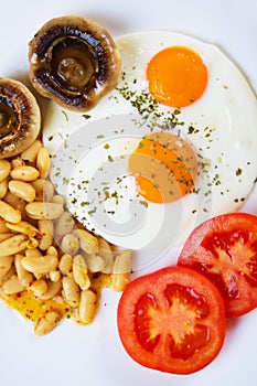 Fried eggs with mushrooms, beans and tomato