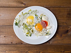 Fried eggs in a plate on a plank background. Delicious breakfast