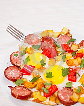 Fried eggs with potato, sausage and pepper