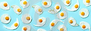 Fried eggs or scrambled eggs pattern on blue background. Creative food concept. Top view. Banner