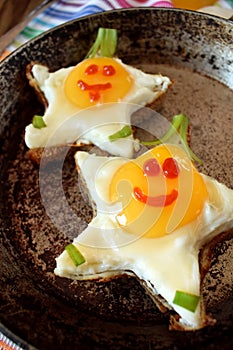 Fried eggs shaped as stars with funny faces