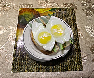 Fried eggs on slices of bread with herbs.