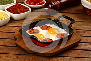 Fried eggs with sucuk on a pan