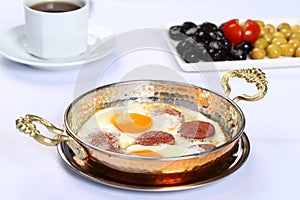 Fried eggs with sucuk on a pan