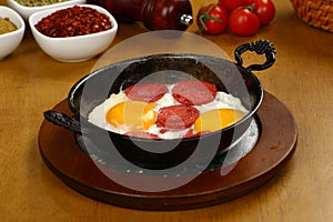 Fried eggs with sucuk on a pan