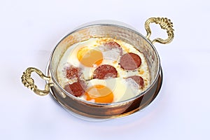 Fried eggs with sucuk on a pan