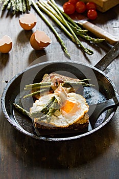 Fried eggs on a toasted bread in a metal pan.