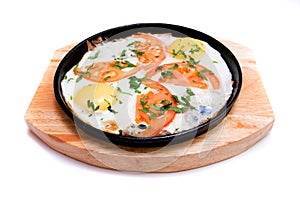 Fried eggs with tomatoes in a frying pan