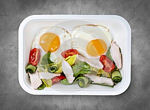 Fried eggs and turkey. Healthy diet. Takeaway food. Top view, on a gray background