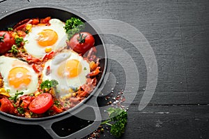 Fried eggs with vegetables: tomatoes, paprika, peppers, onions. Vegetable Shakshuka in a pan. Top view.