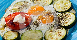Fried eggs with zucchini and tomatoes