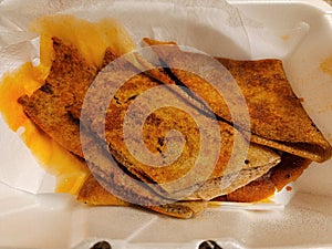 fried Ethiopian bread called injera with spices in container