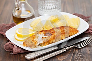 Fried fillet of fish with boiled potato on white dish