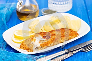 Fried fillet of fish with boiled potato on white dish
