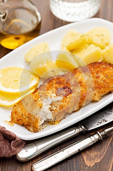 Fried fillet of fish with boiled potato on white dish