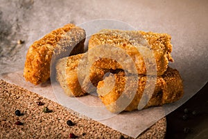 Fried fish on baking paper with peppercorns