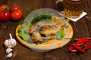 Fried fish with beer on wooden table