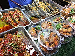 Fried fish with chili and spicy sauce in the market of Thailand