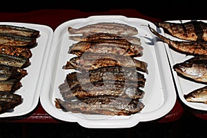 fried fish cooked entirely on an open fire on the embankment near the Black Sea on the grill. Reportage shooting. Republic of Crim