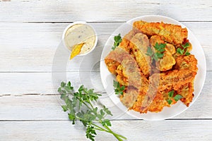 Fried fish decorated with parsley, top view