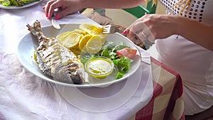Fried fish dorada on plate with potatoes and vegetables
