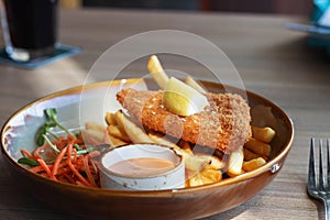 Fried fish fellet wiht french fries and veggies on plate