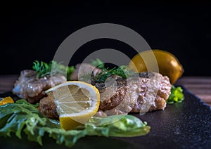 Fried fish with lemon and lettuce leaves