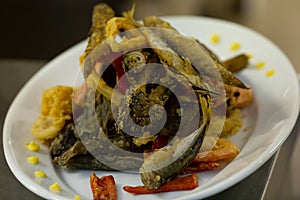 Fried fish in oil with calamar rings and pimiento peppers