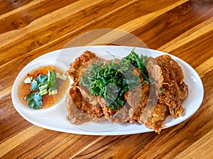 Fried fish paste balls or deep fried fish cake and fried basil on white plate
