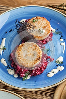 Fried fish rissole served with beetroot on blue plate on wooden table