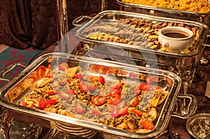 Fried fish with salad tomatoes, and roast beef with sauce, and other food served in chafing dishes