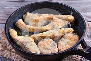 Fried fish snacks on frying pan. pieces of fried fish. pieces of fried fish in boiling oil. pieces of fried fish in hot oil in a f