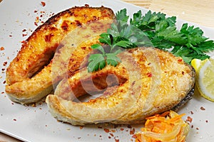 Fried fish, steaks fish, red fish on a plate on a wooden background