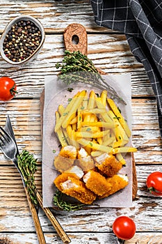 Fried Fish Sticks with French Fries. British fish and chips, fried potato. White wooden background. Top view