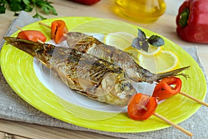 Fried fish (carp) on skewers with pieces pepper