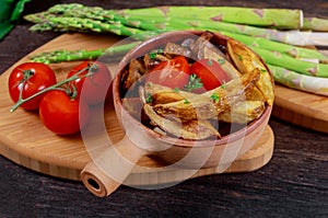 Fried french potato with mushrooms fresh green asparagus and tomatoes