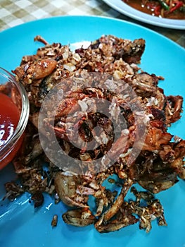 Fried Frogs with Salt and Black Pepper. on blue plate