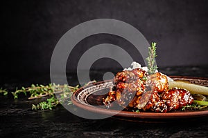 Fried glazed chicken wings in soy sauce and sesame. Cheese white sousa. Marinated vegetables on a ceramic plate. Background image