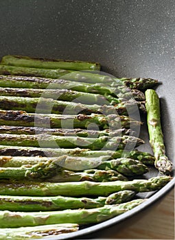 Fried green asparagus straight from the pan photo
